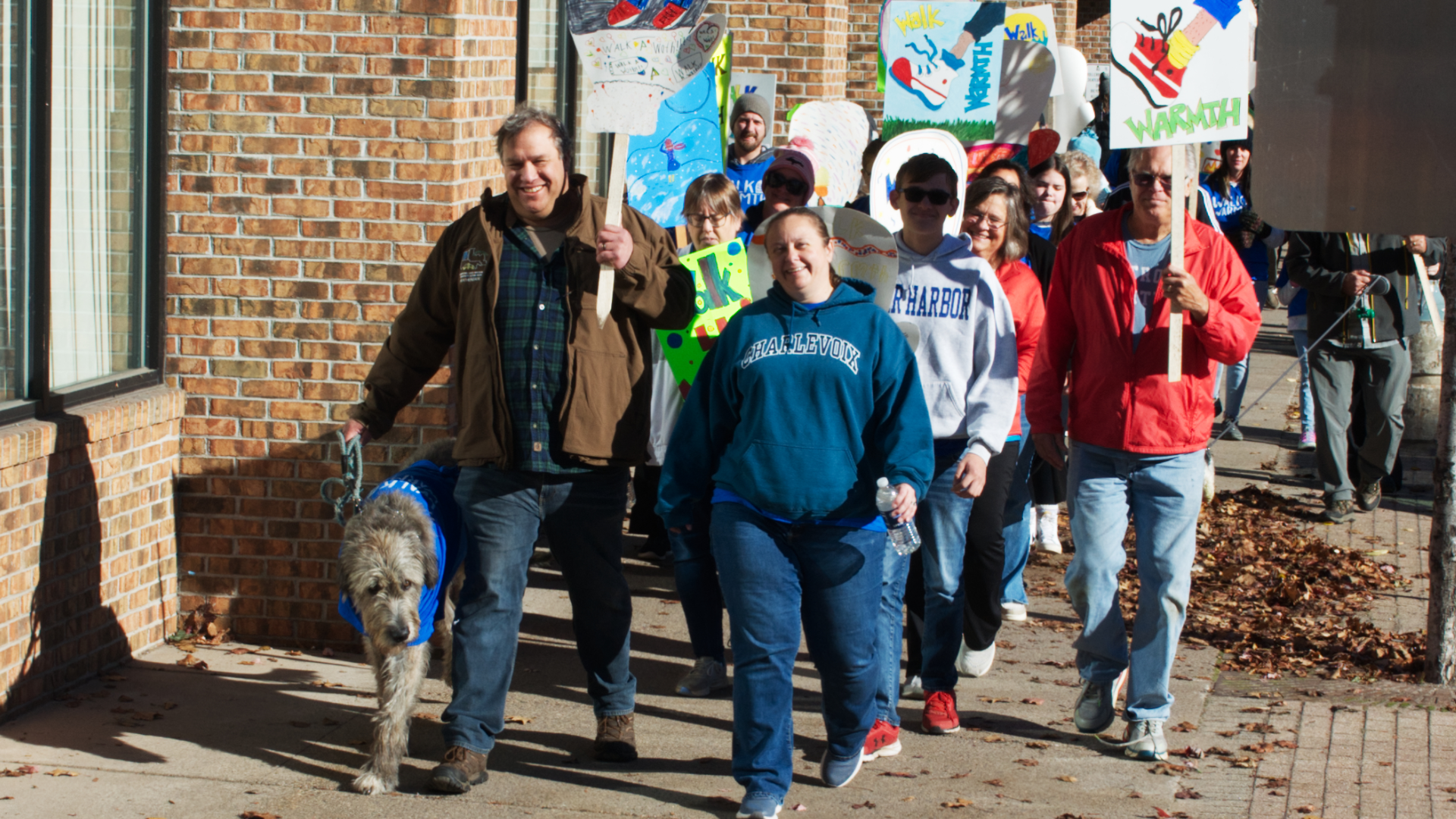 Walkers and puppers are all smiles walking down the sidewalk to support the cause